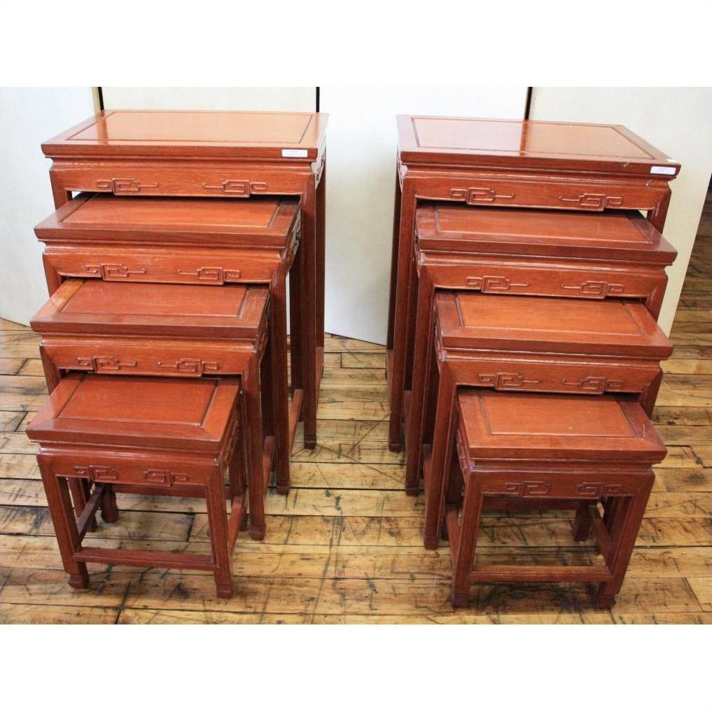Reddish rosewood nesting tables, two sets placed side by side on a wooden floor.