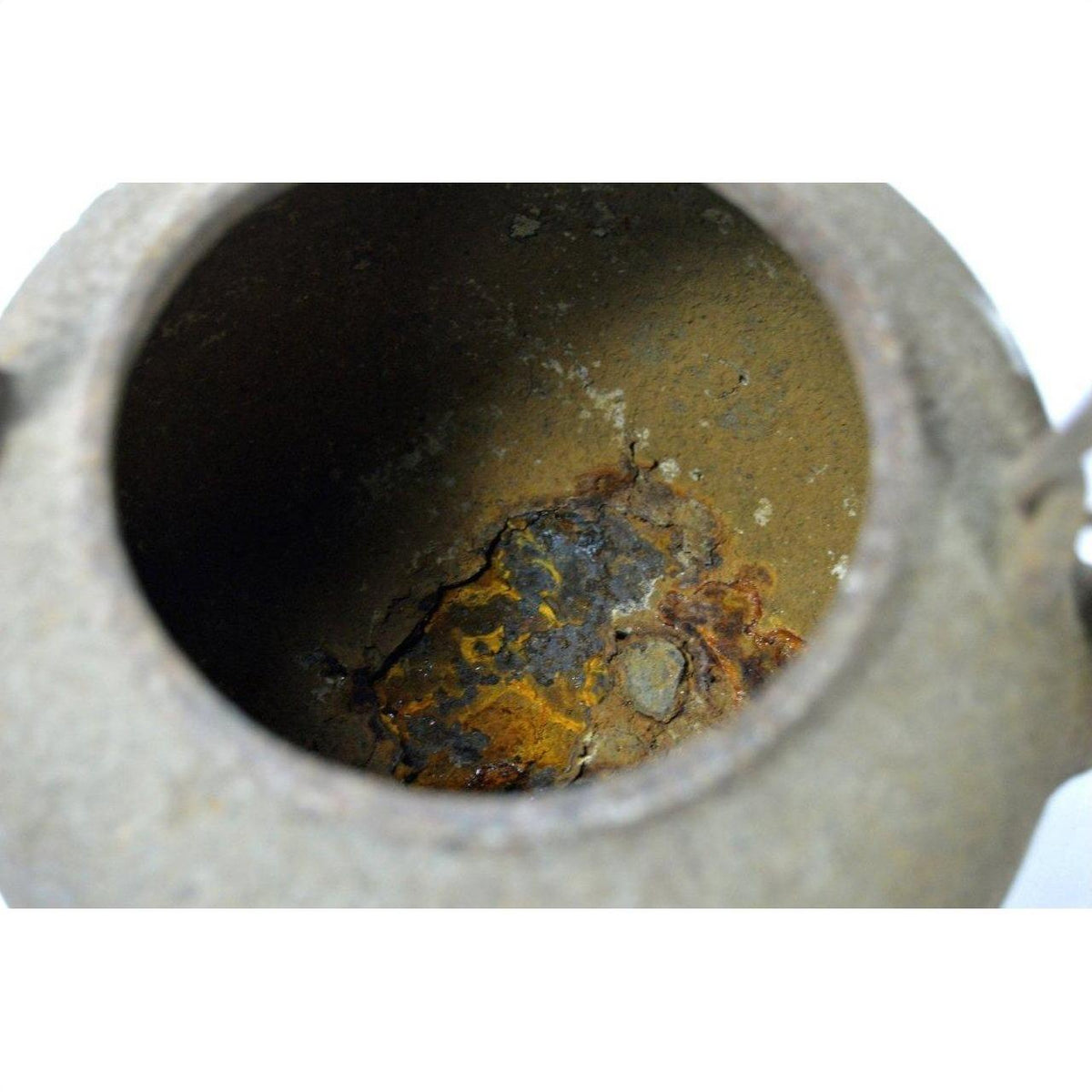 Close-up of brown metal Japanese teapot interior with rust and mineral deposits, used condition.