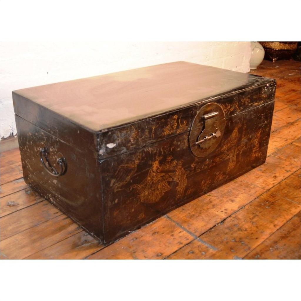 Dark wooden vintage chest with metal handles and lock on a wooden floor.