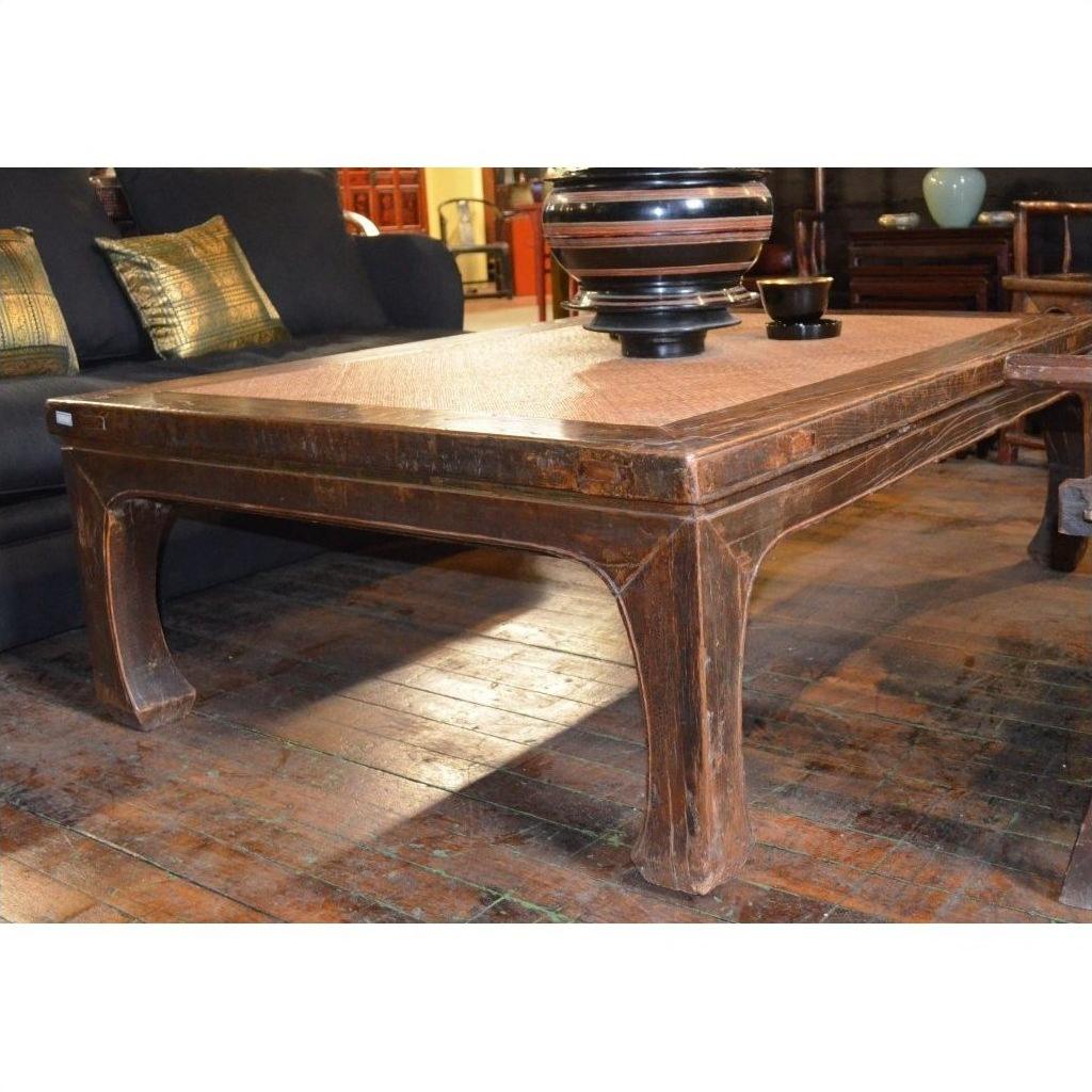 White lacquer coffee table on wooden floor, styled with bowls and decorative items on top.