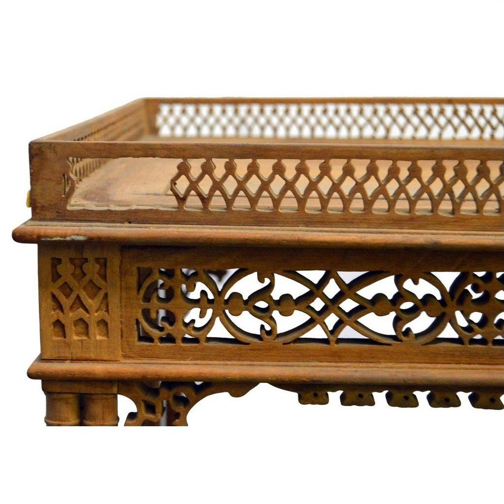 Brown wooden hand carved table with ornate lattice designs and a raised decorative border, vintage style.