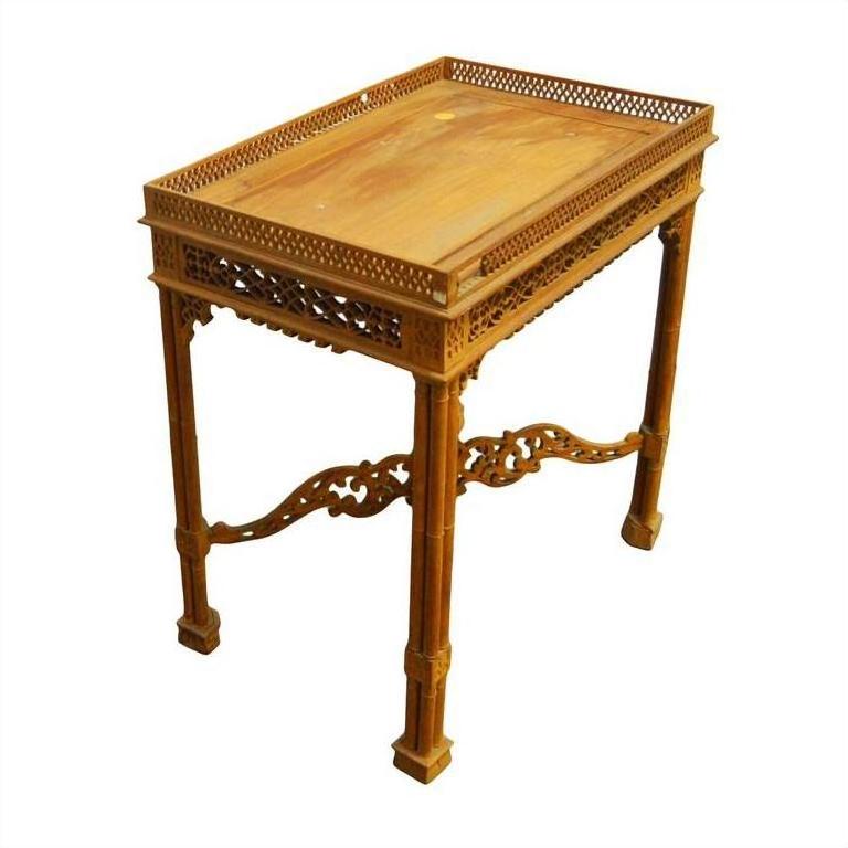 Brown wood hand carved table with intricate latticework and detailed carvings on legs and edges, close-up view.