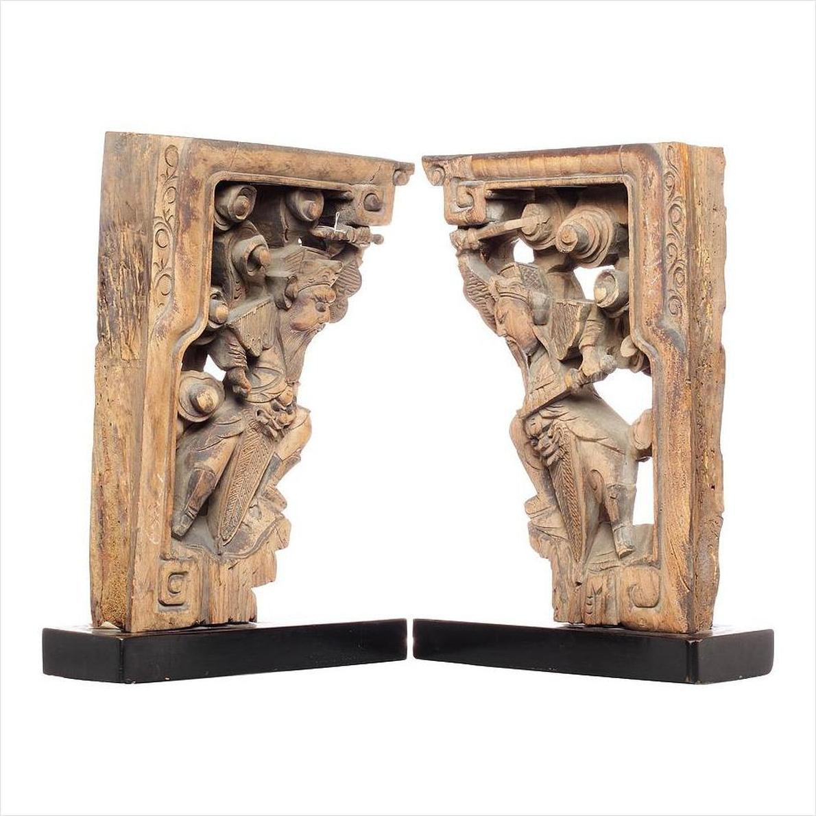 Black wooden 18th-century Chinese temple corbels with hand-carved character designs on rectangular bases.
