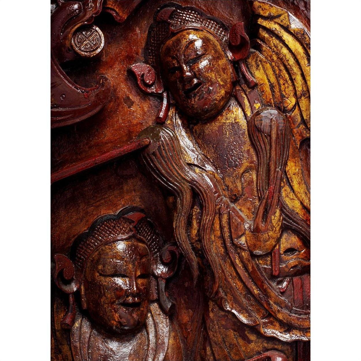 Brown and gold wood Chinese carvings with serene expressions and flowing robes, close-up view.
