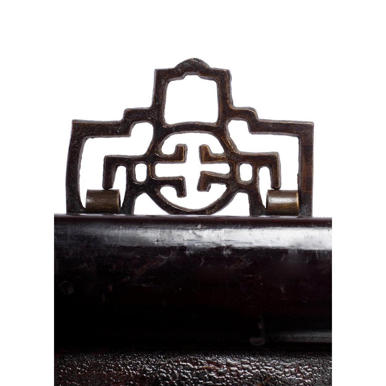 Close-up of brown Chinese wood carvings with ornate geometric and circular patterns on a white background.