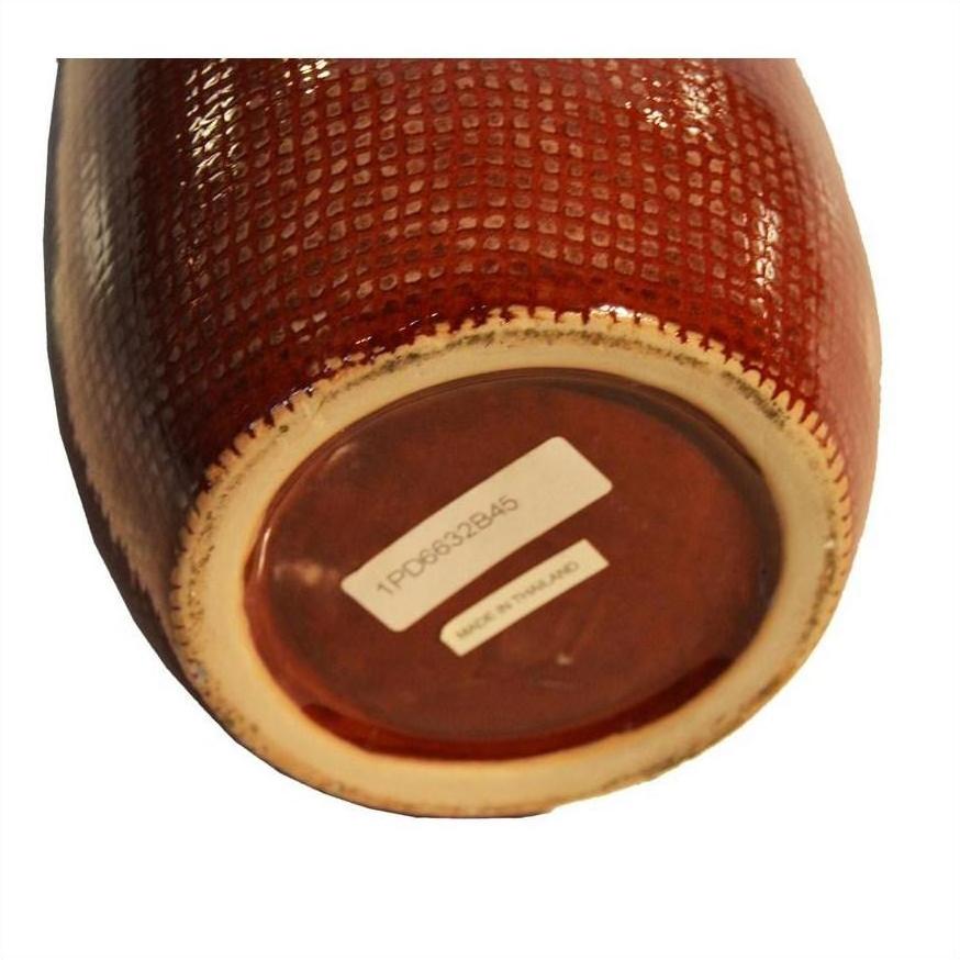 Close-up of the bottom of a white ceramic vase with barcode sticker and Made in Thailand label.