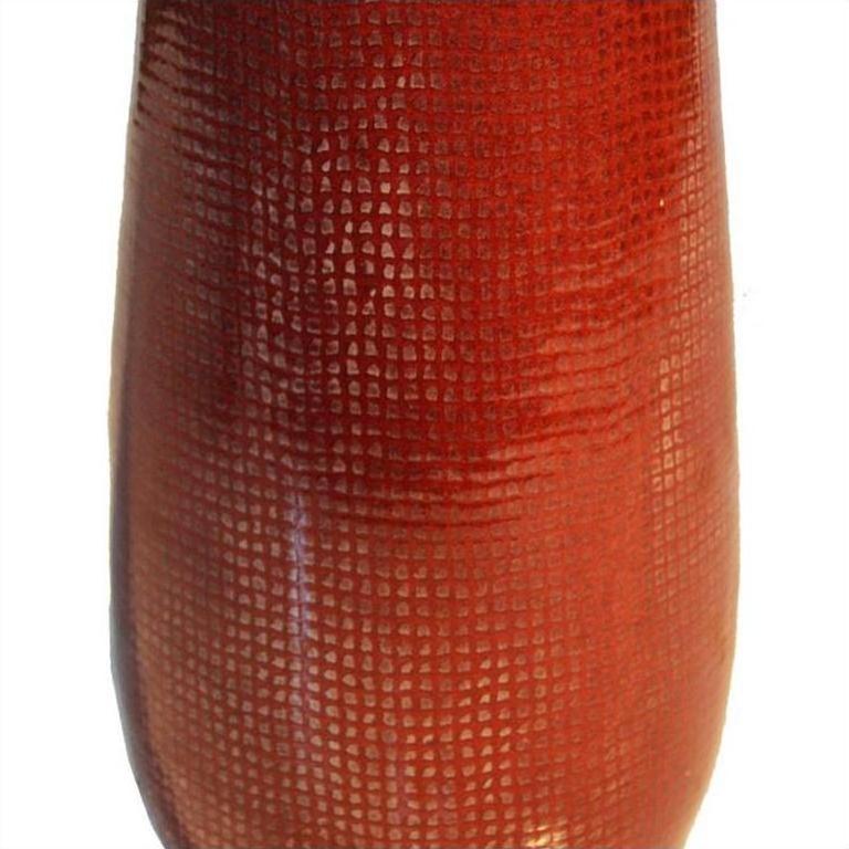Close-up of reddish-brown ceramic vase with textured grid-like surface.