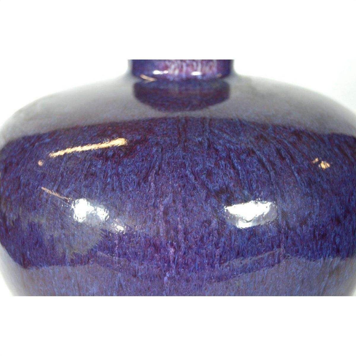 Close-up of deep purple glazed ceramic vase with glossy finish and visible light reflections, very good condition.