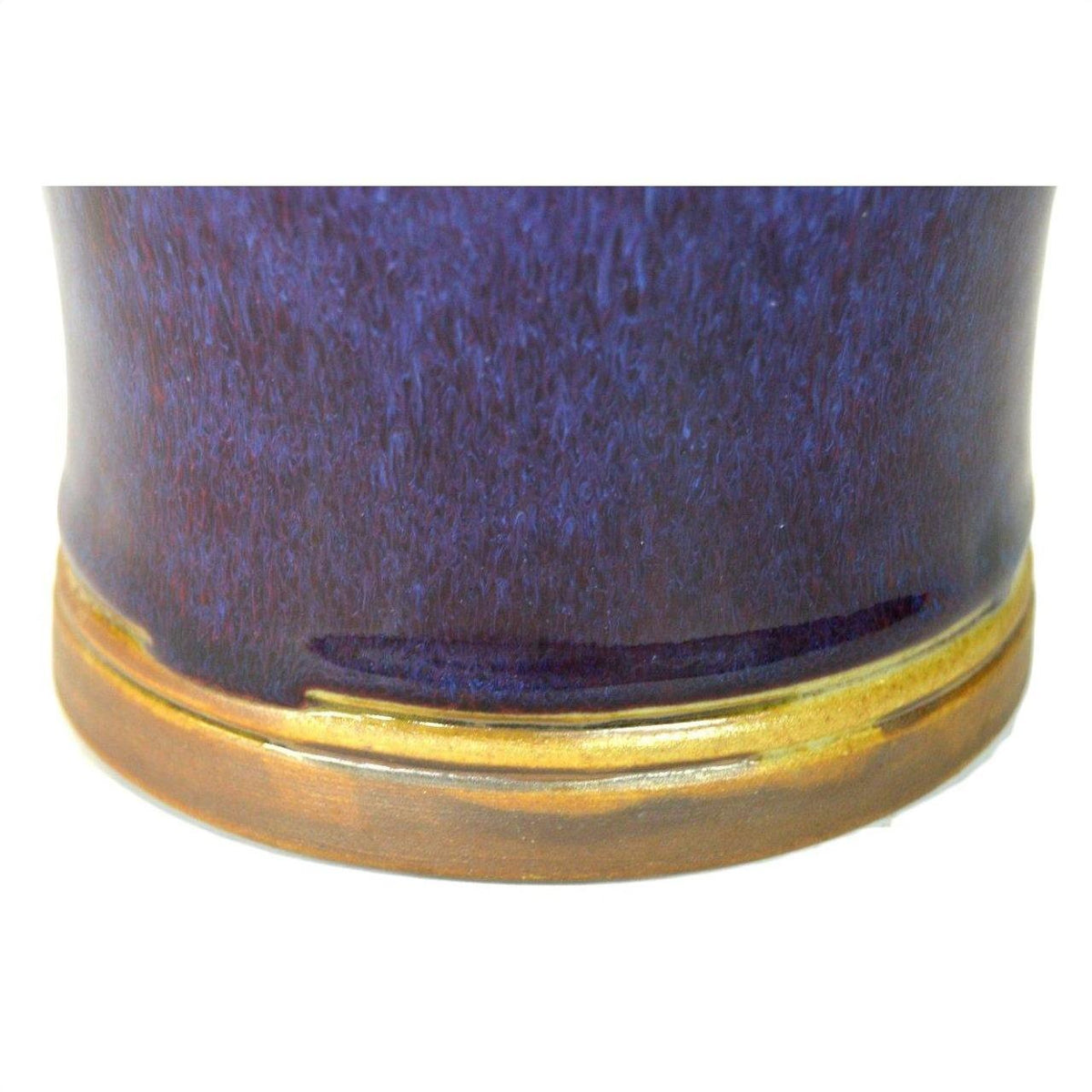 Close-up of glossy dark blue ceramic vase with brown base, in very good condition.