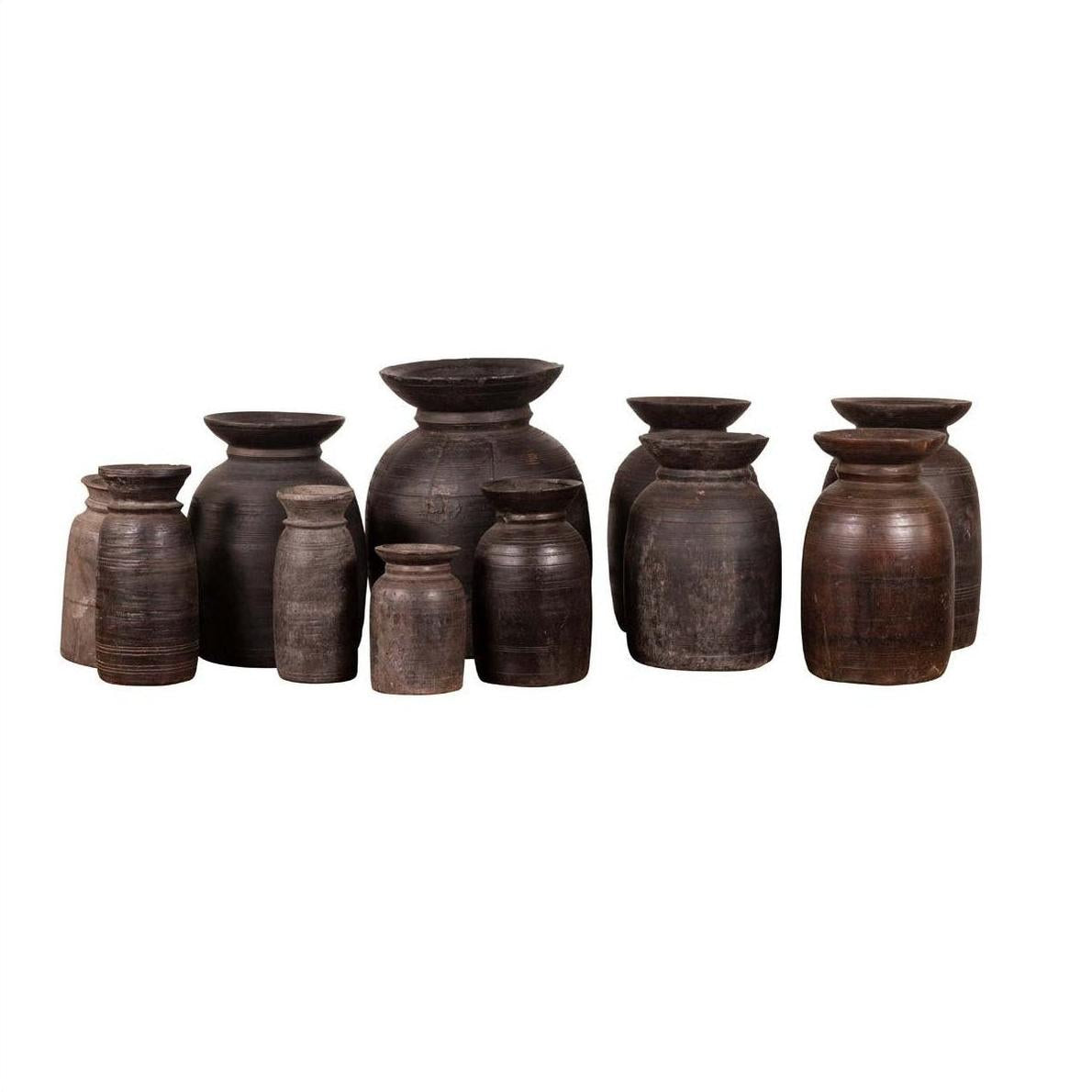 Brown wooden ghee pots, primitive and rustic, set of three, five, or seven on a white background.