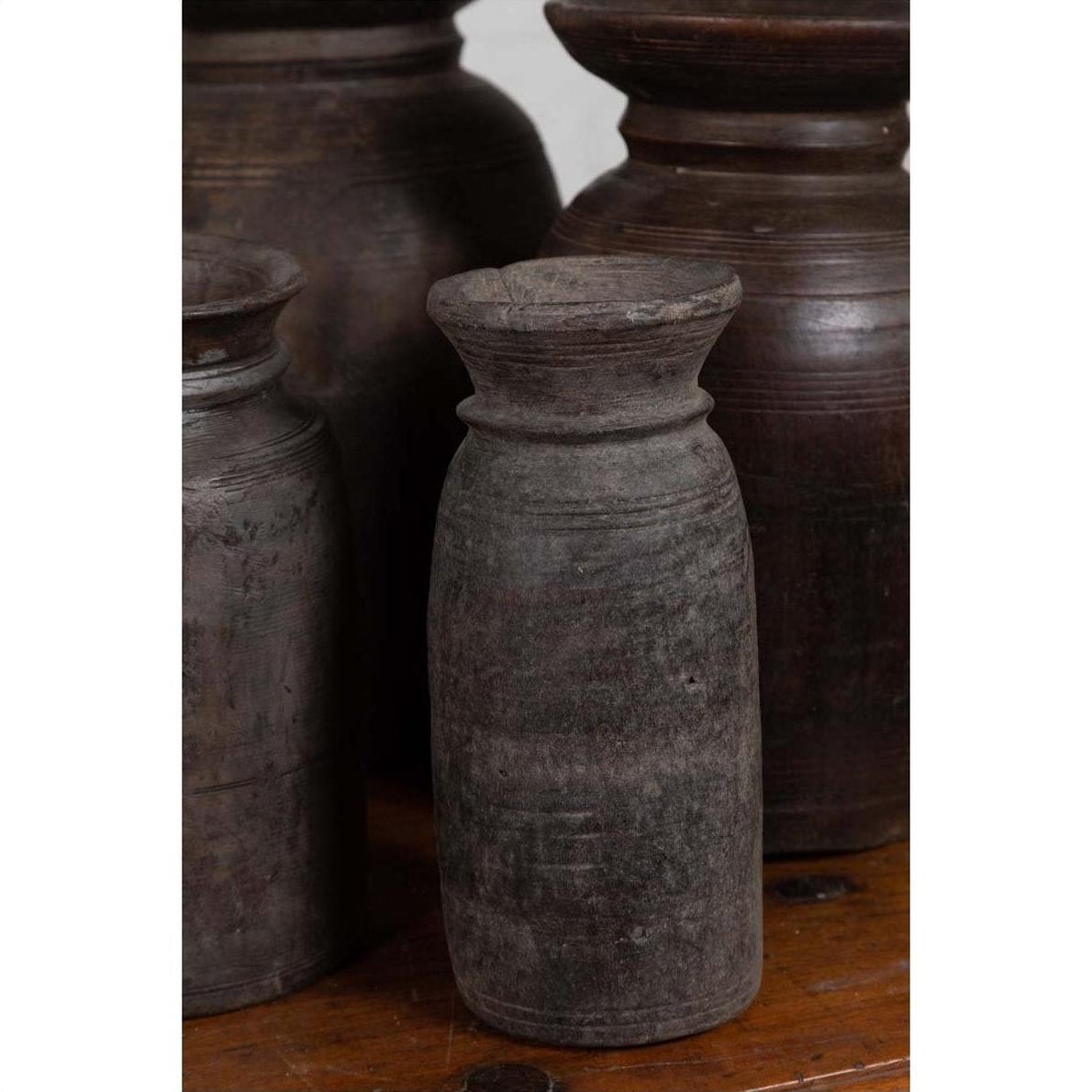 Brown wooden ghee pots in sets of 3, 5, or 7 on a rustic wooden surface.