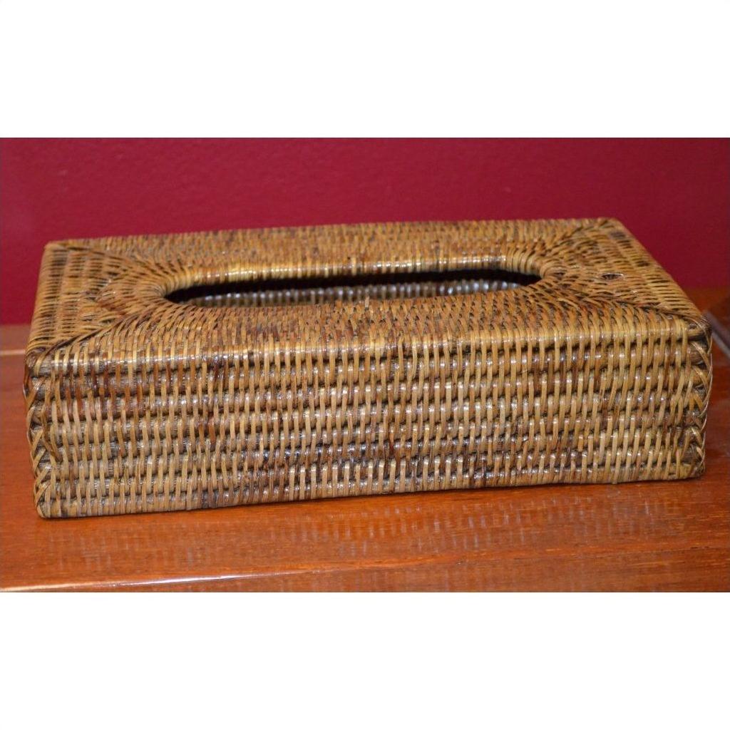 Close-up of a brown rattan tissue box on a wooden surface with a red wall in the background.