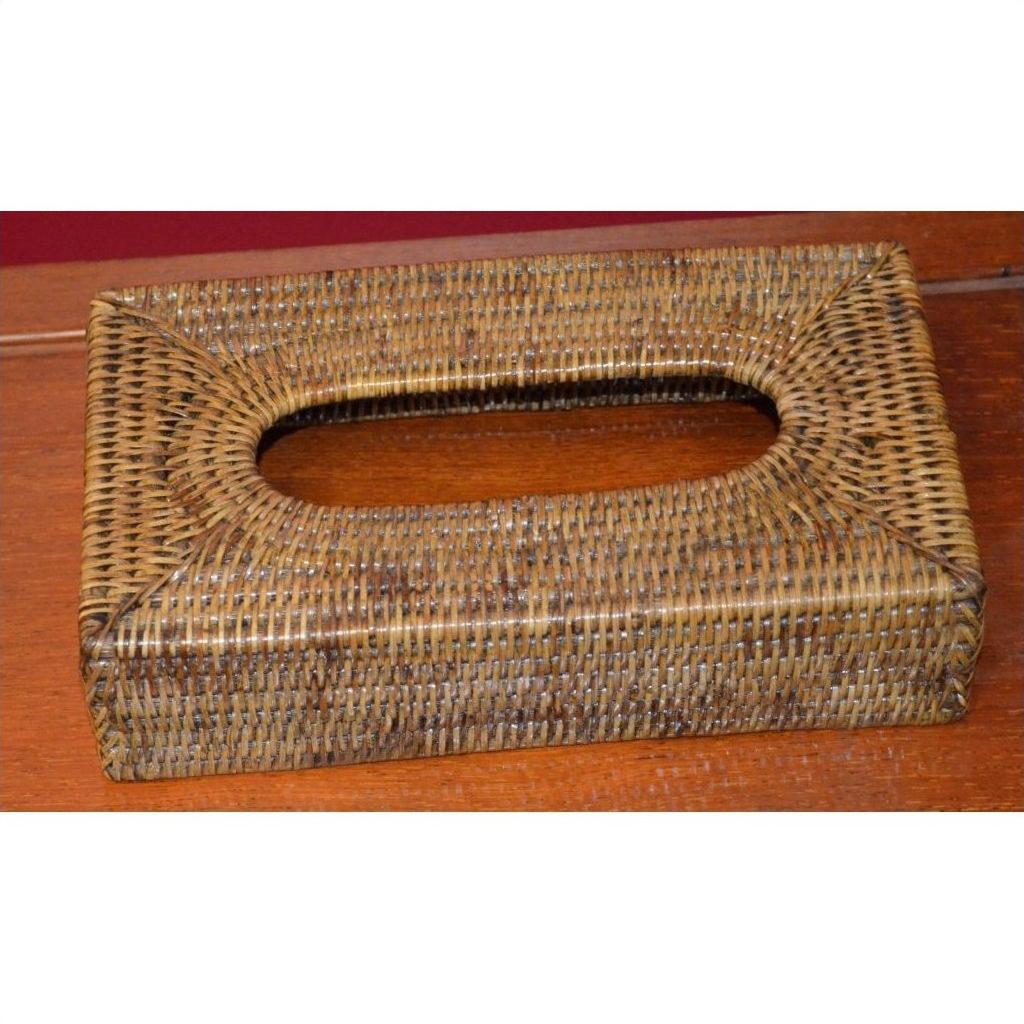 Brown hand-woven rattan rectangular tissue box with oval top opening, close-up on a wooden surface.