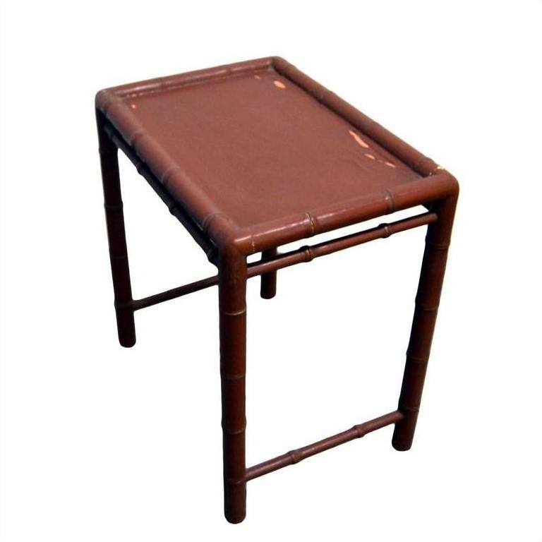 Red bamboo side table with small rectangular top and bamboo-style legs, close-up view.