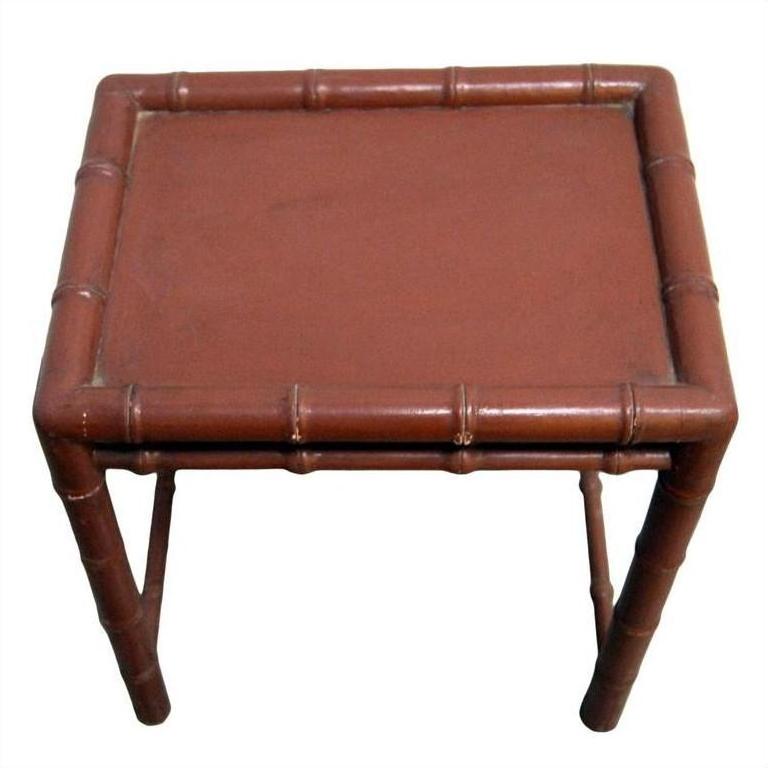 Close-up of a small, square red bamboo side table with bamboo-inspired legs and edges.