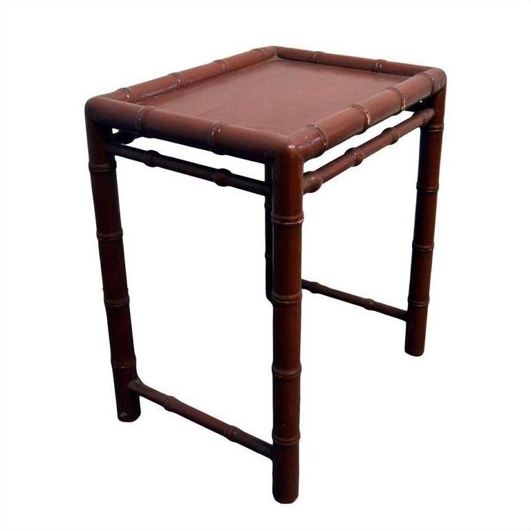 Red wooden bamboo-style side table with rectangular top and bamboo-inspired legs and edges, close-up view.