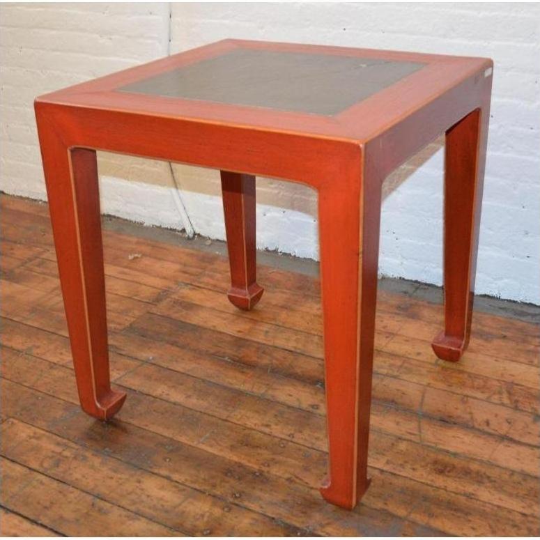Red side tables with inset floor tile, pair, placed on wooden floor against a white brick wall.