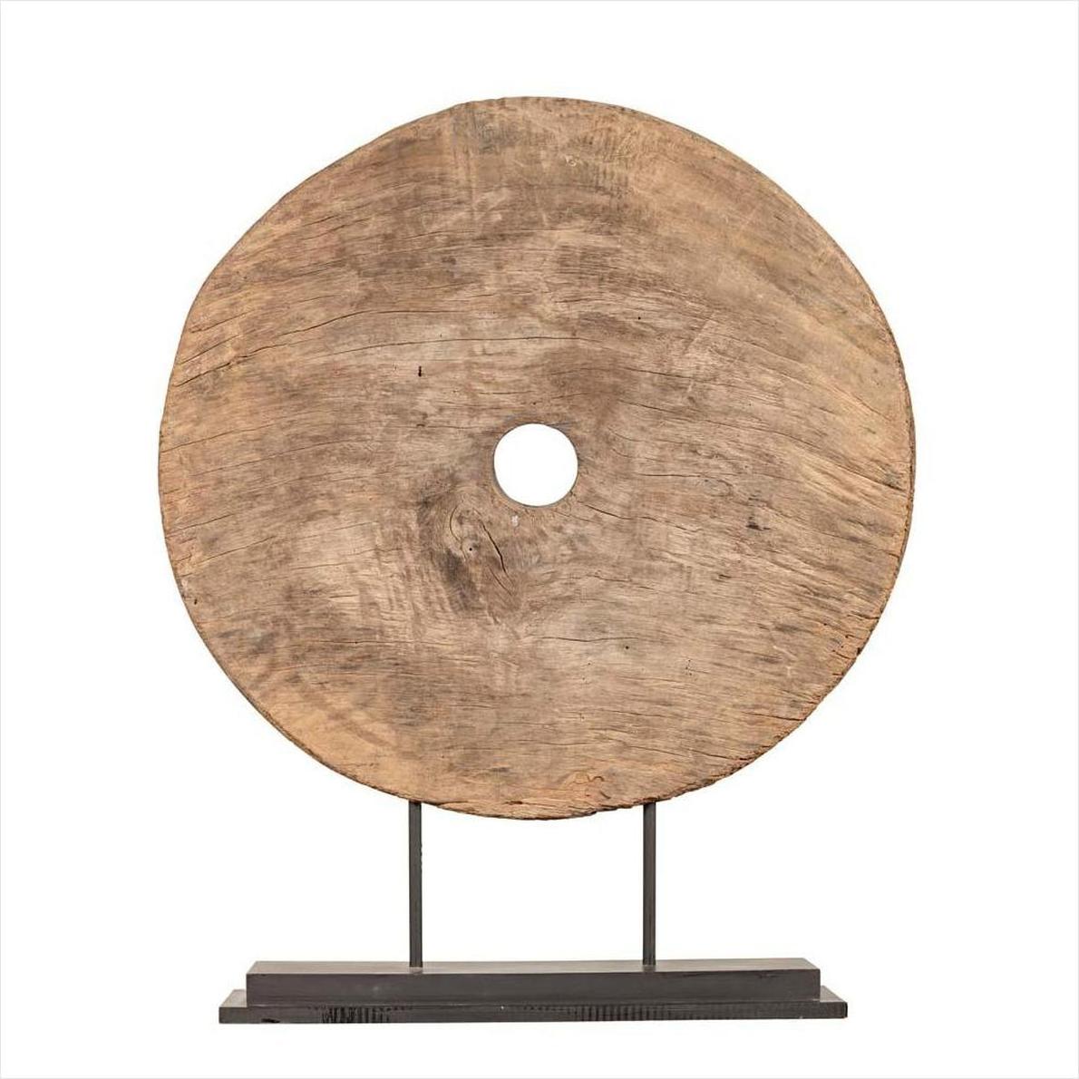 Brown wood ox cart wheel with central hole, 19th century Thailand, displayed on black painted base.