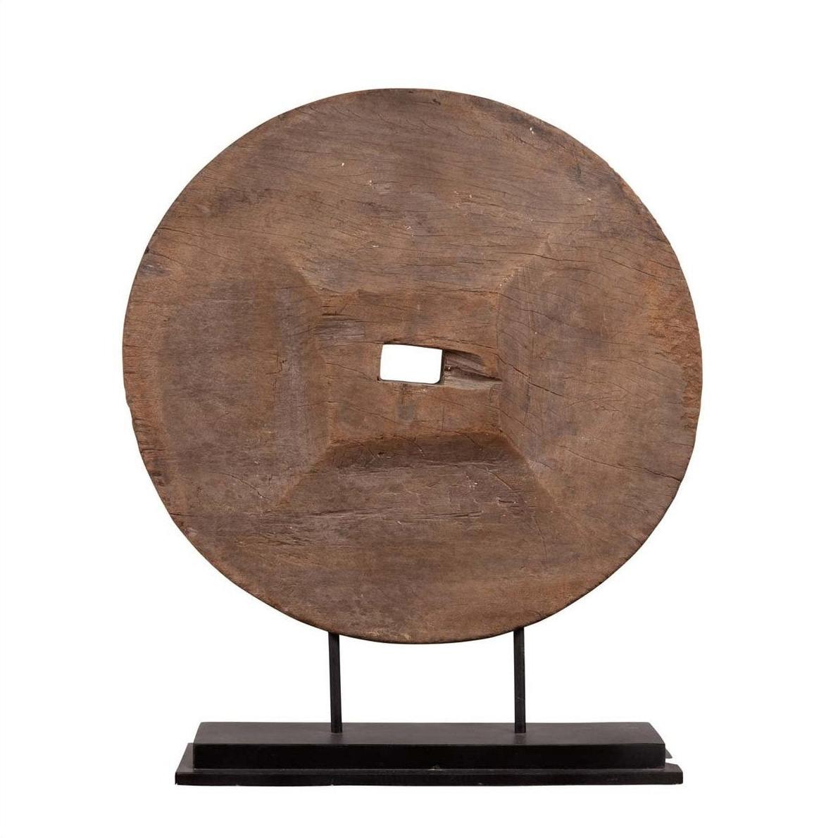 Brown wooden ox cart wheel from Thailand on black base, displayed indoors.