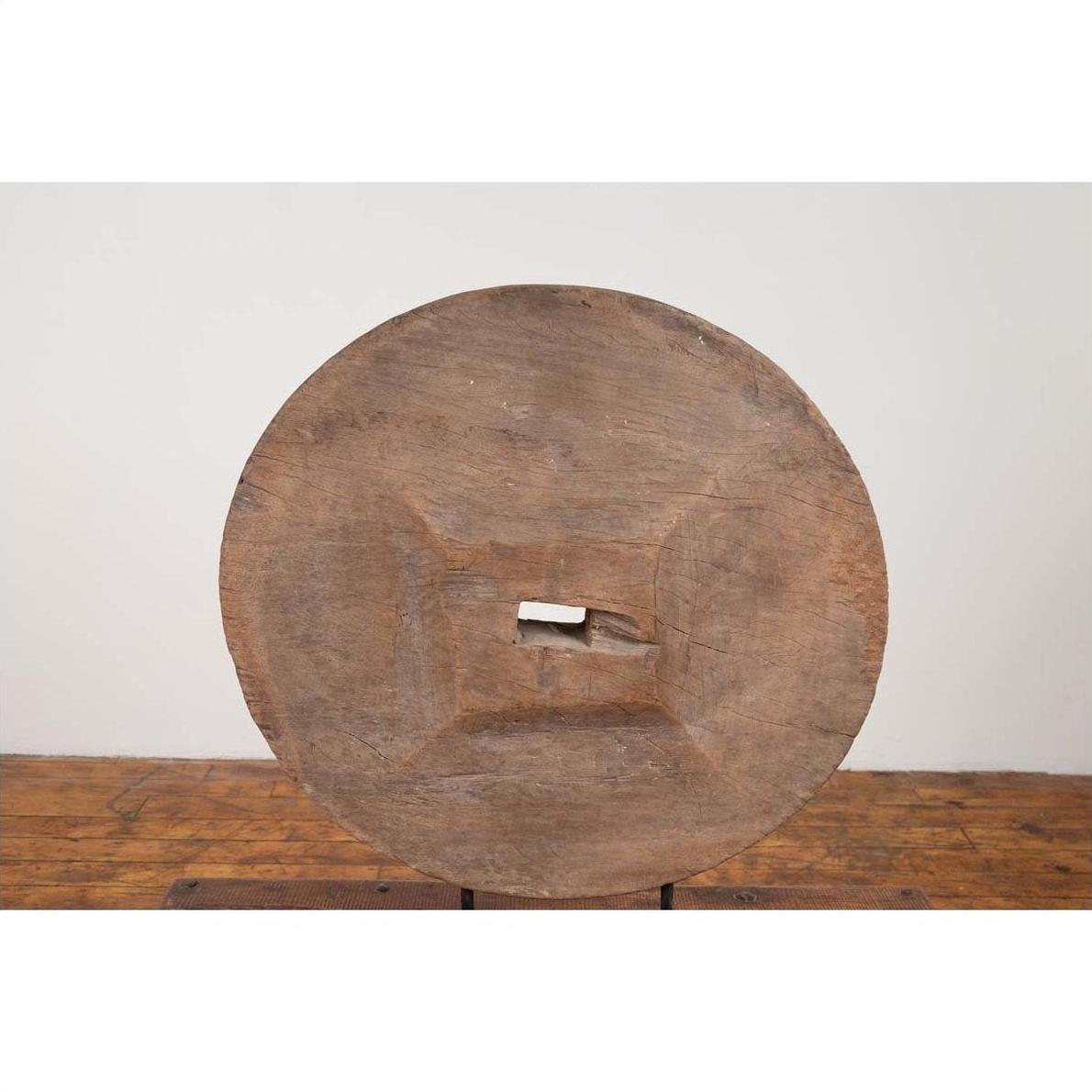 Weathered wood ox cart wheel with square center on black painted base, Thailand, 19th century.