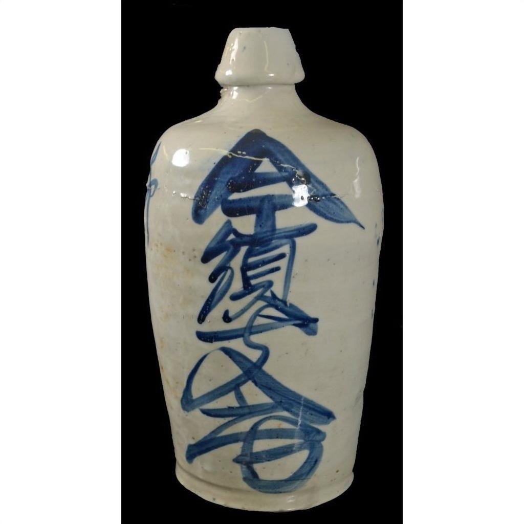 Close-up of white ceramic Seto Ware sake jar with blue kanji characters painted vertically on the front.