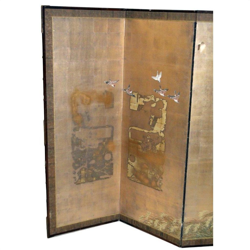 Gold Japanese folding screen with flying birds and abstract weathered patterns on a shimmering background.
