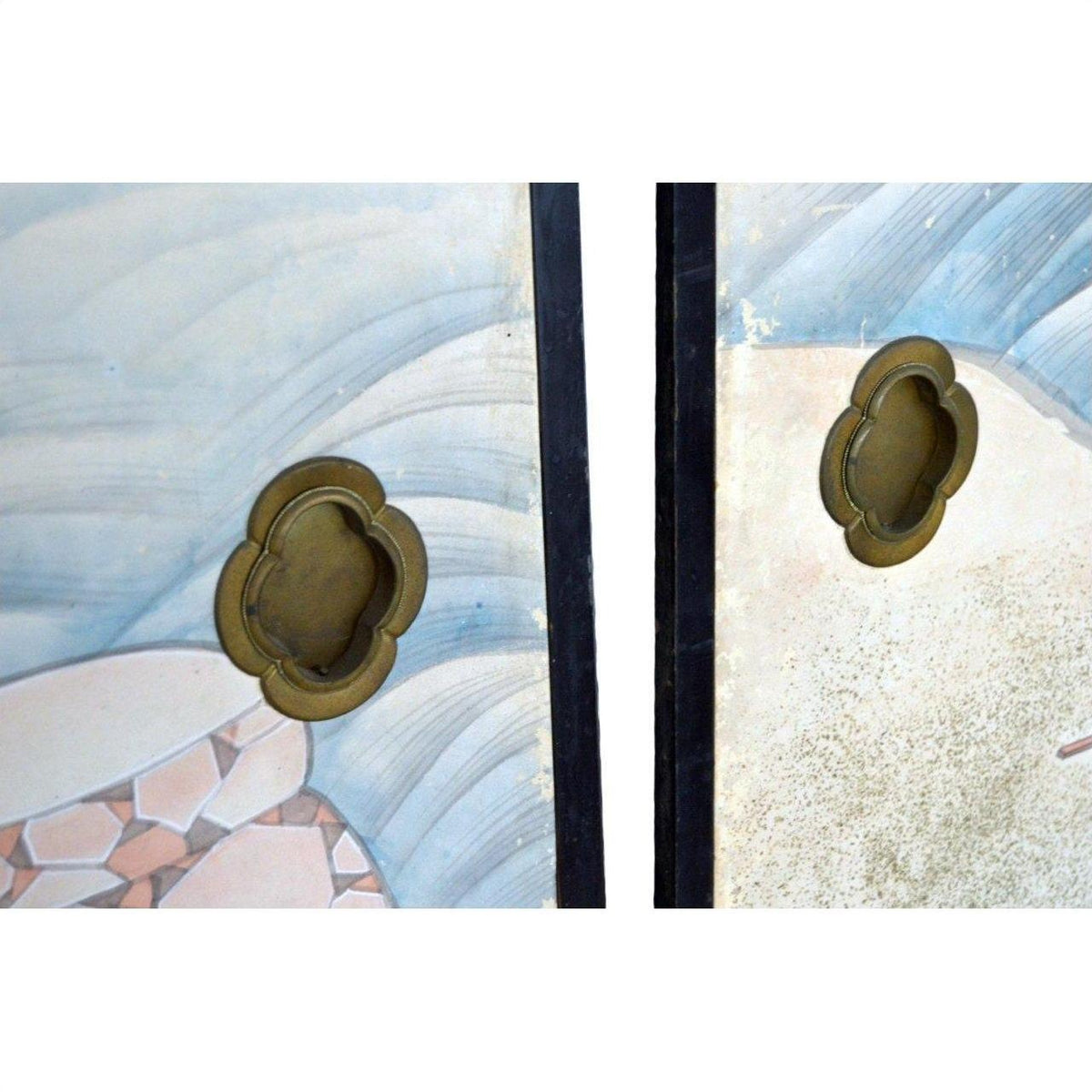 Close-up of two brass handles on vintage Japanese 2-panel screen with fictional character designs.