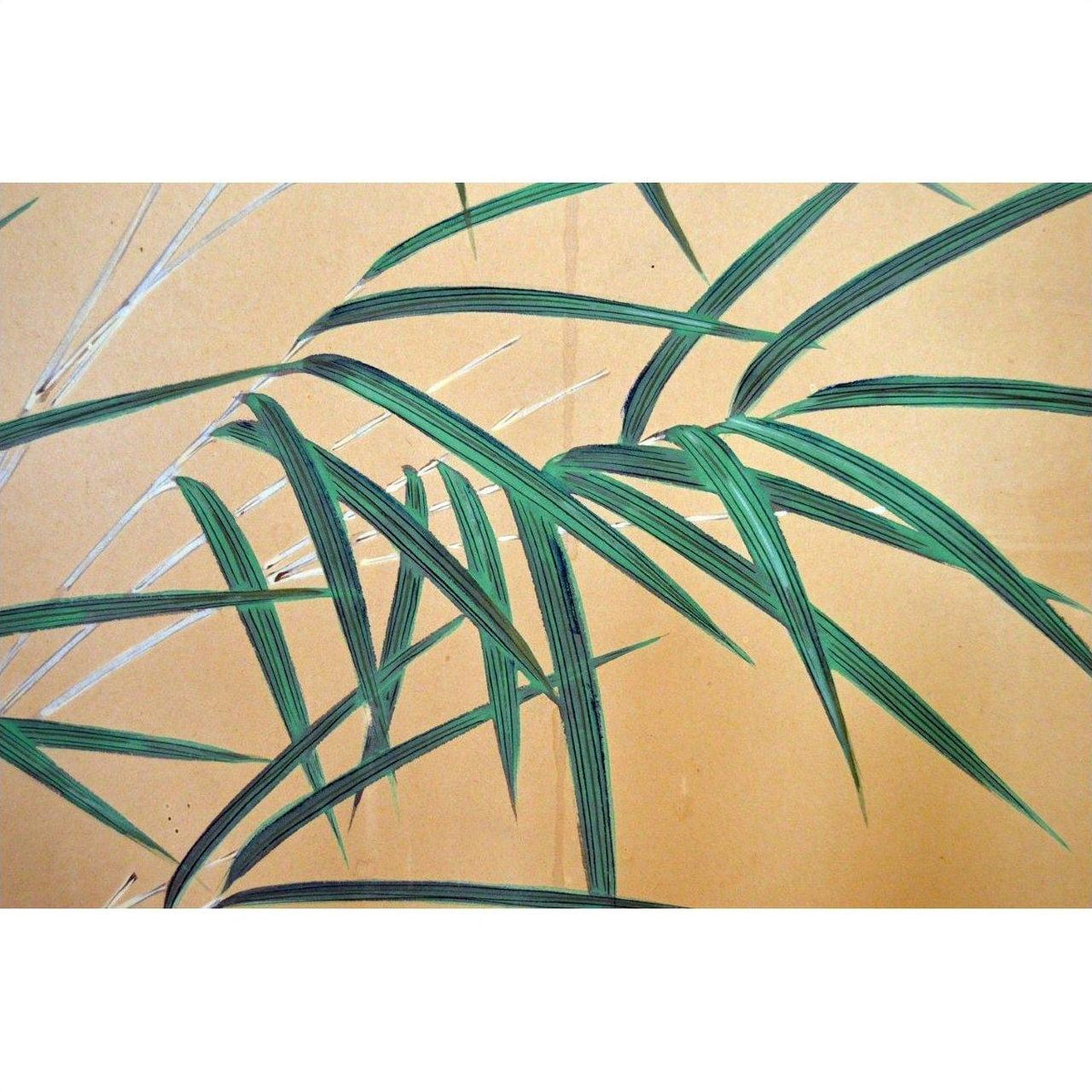 Black and gold 2-panel screen with painted flowers, birds, and bamboo leaves, used as room divider indoors.