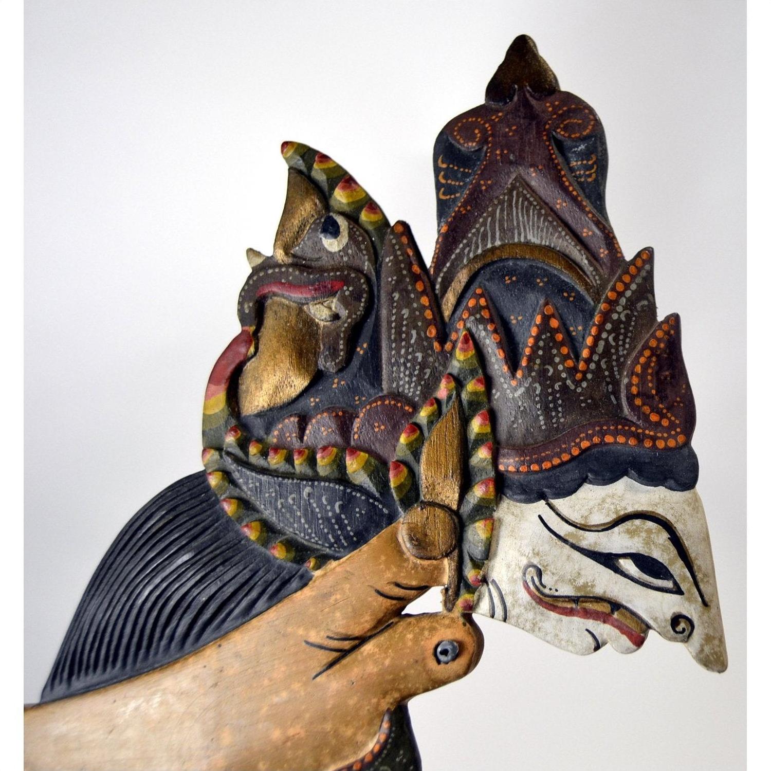Brown painted wooden Wayang Kulit shadow puppets with stylized faces and ornate headpieces, set of 3.