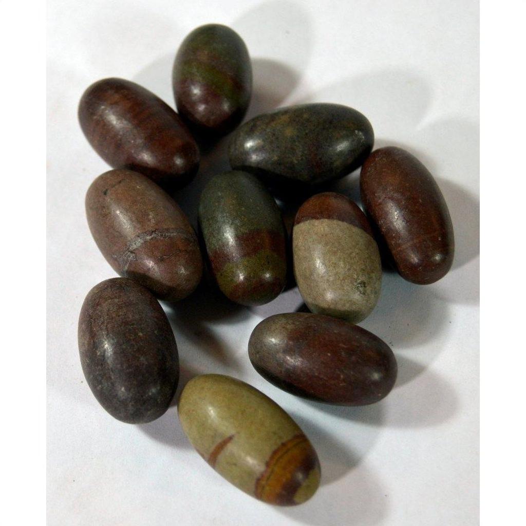 Brown and greenish smooth oval Shiva Lingam stones, stone material, close-up on white background.