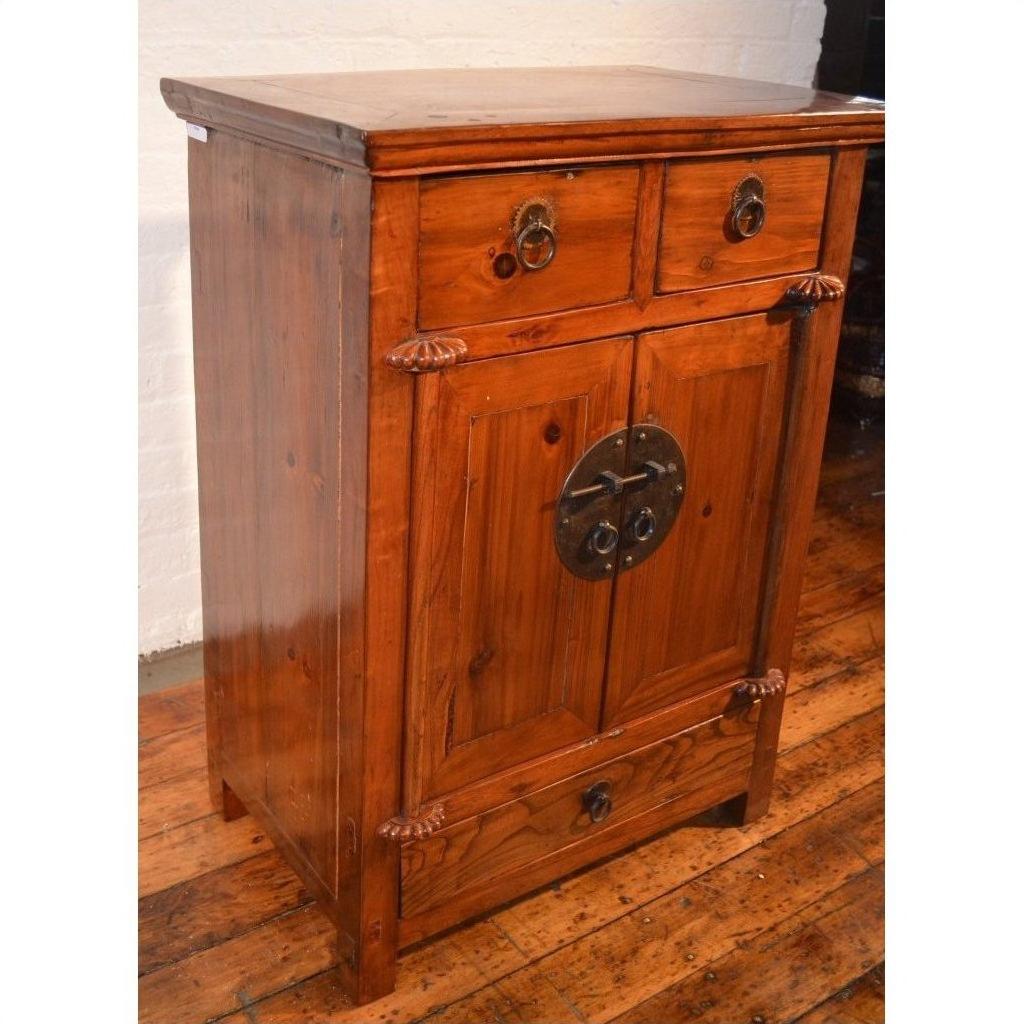 Brown wood side cabinet with metal handles, two small drawers, double doors, and lower drawer on wood floor.
