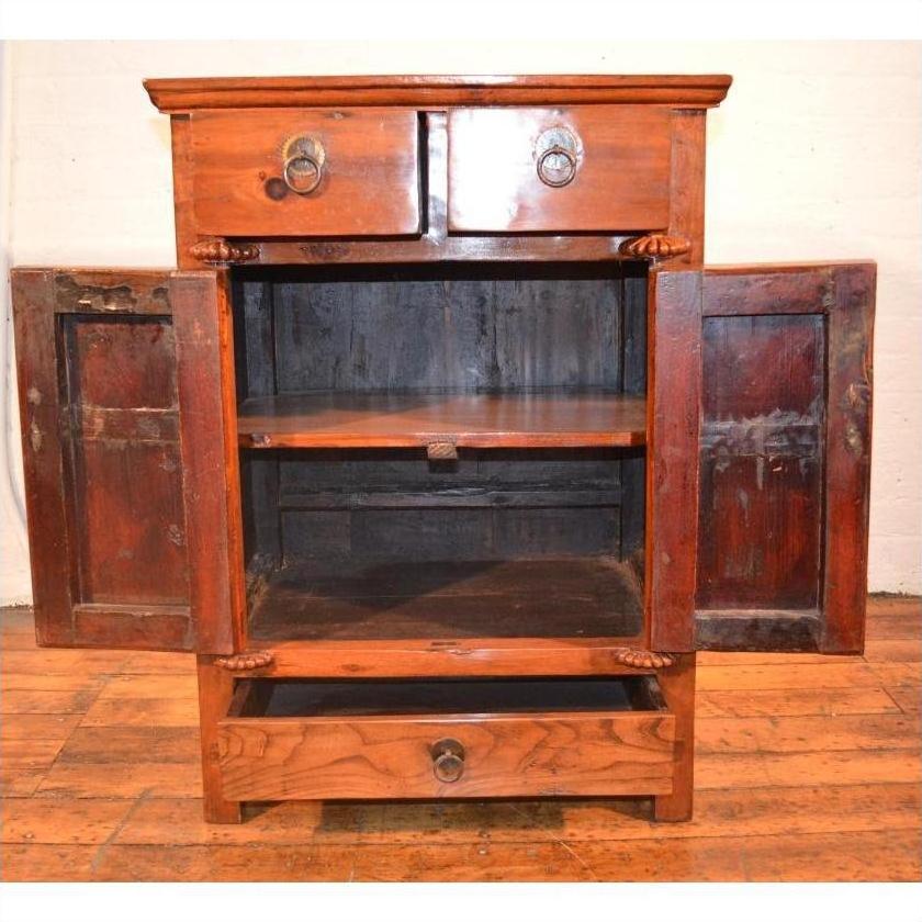 Wooden side cabinet with two open doors, two top drawers, and a bottom drawer on a wooden floor.