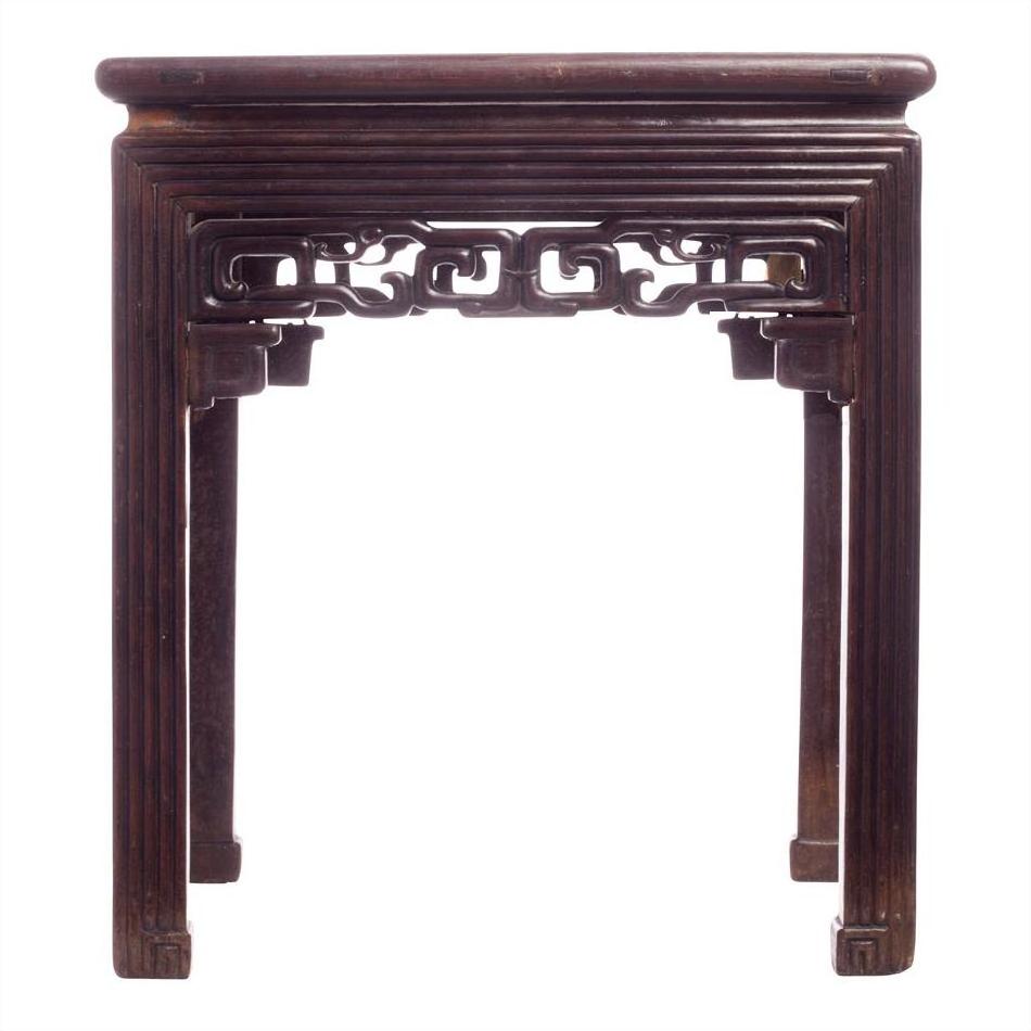 Brown wood side table with carved fretwork apron, straight legs, and detailed carved sides, front view.