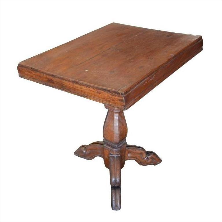 Brown wooden Colonial tripod table with rectangular top and central pedestal, natural patina finish, close-up view.