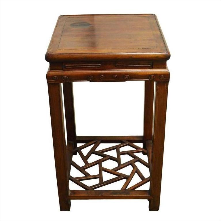 Black metal side table with a square top and geometric cracked ice pattern base shelf, studio view.