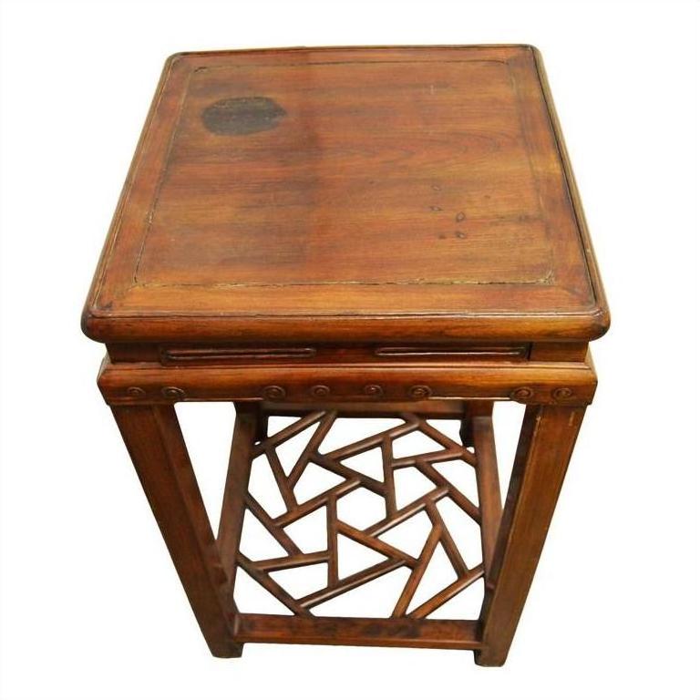 Dark wood side table with geometric cracked ice base and visible dark stain mark on the top surface, close-up view.