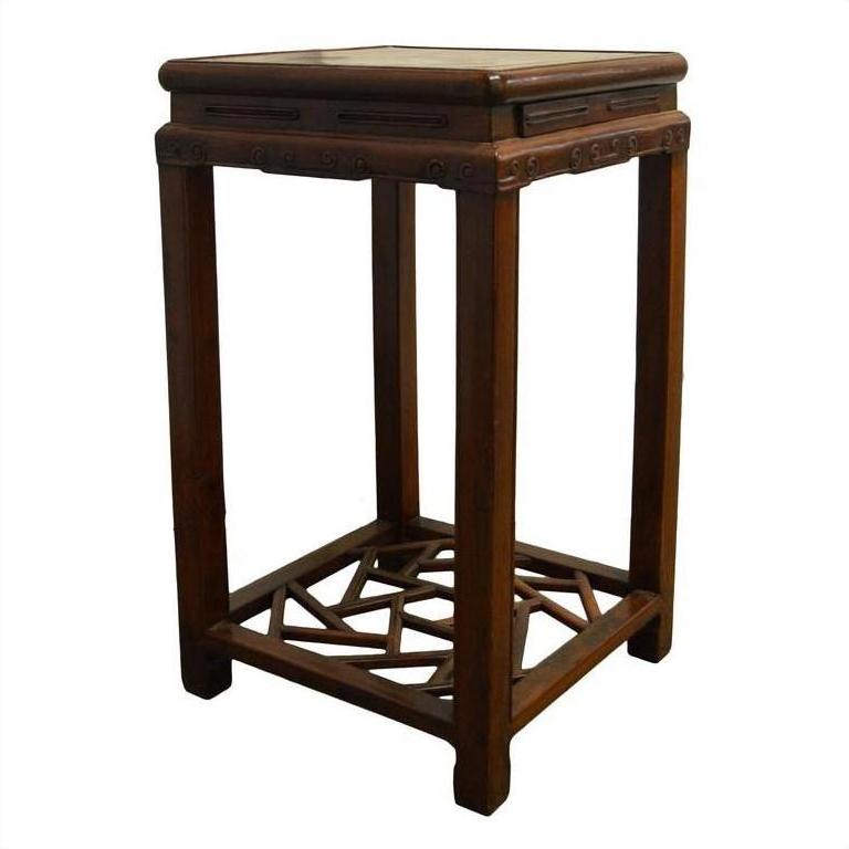 Wooden side table with decorative carvings and geometric cracked ice base, close-up view.