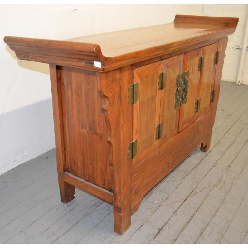 Wooden sideboard with everted flanges, metal hinges and handles, raised back edge, and paneled doors.