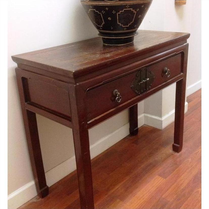 Black and gold side console table with horse hoof legs, metal accents, drawer, decorative bowl on top.