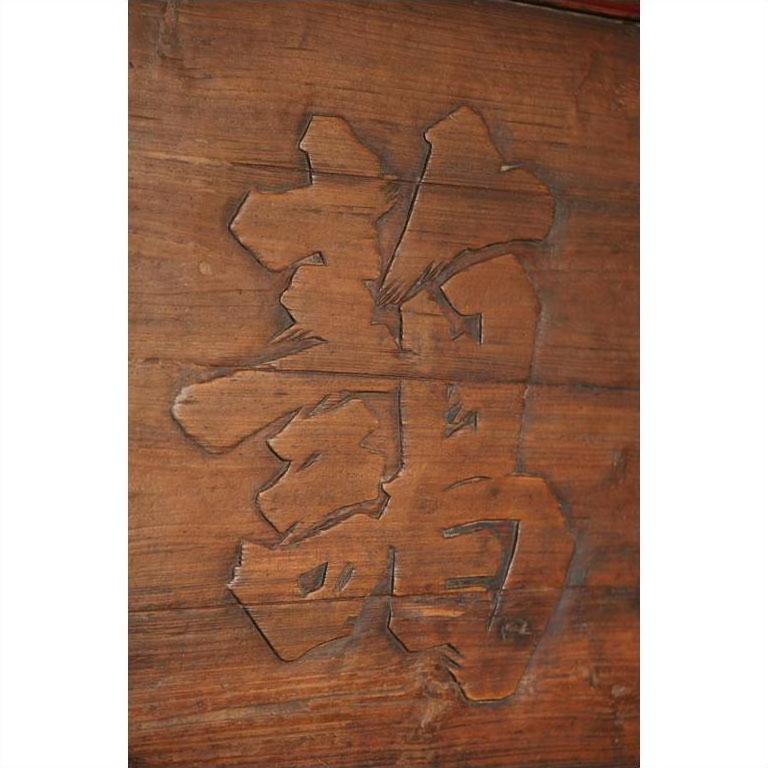 Close-up of a wooden signboard featuring a carved Chinese dragon (龙/龍) character.