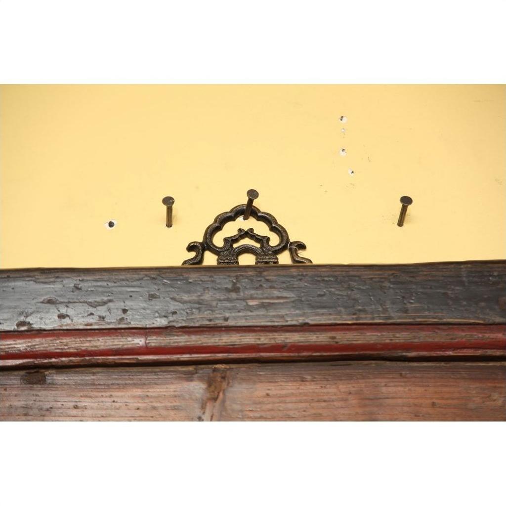Close-up of a signboard mounted on a yellow wall above dark wooden trim.