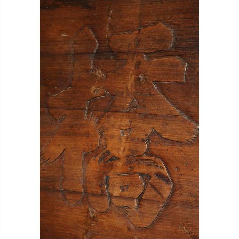 Brown carved wooden signboard with bold engraved Chinese characters.
