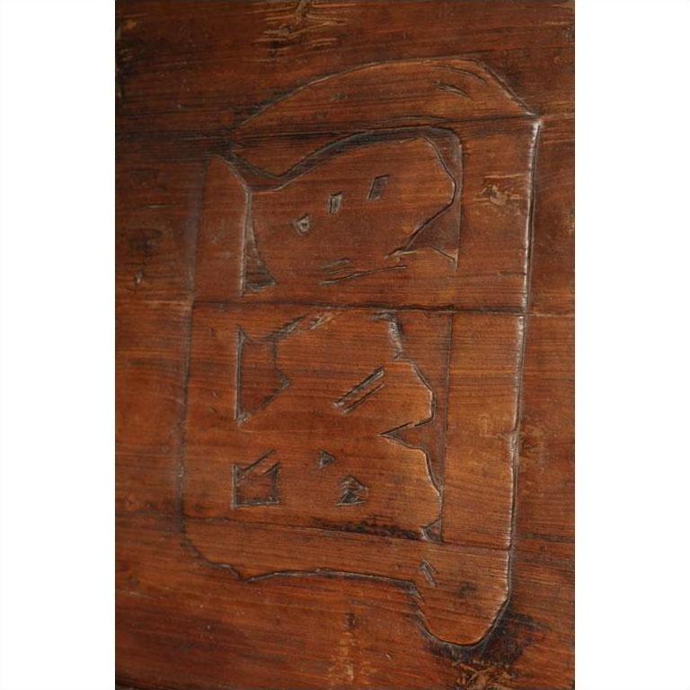 Brown wood signboard close-up with carved Chinese characters, showing intricate grain and texture.