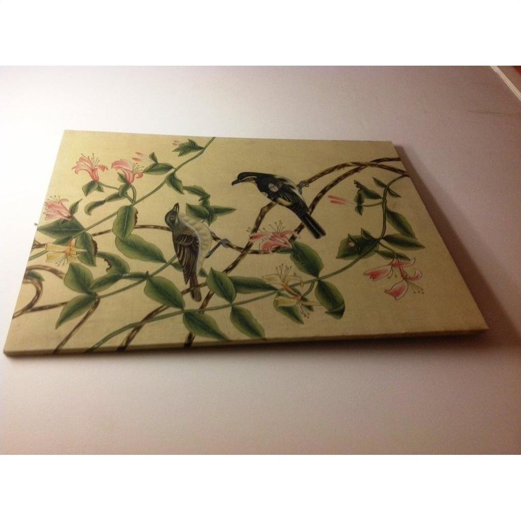 Framed silk painting with colorful birds on branches, pink flowers, and green leaves on a light background.