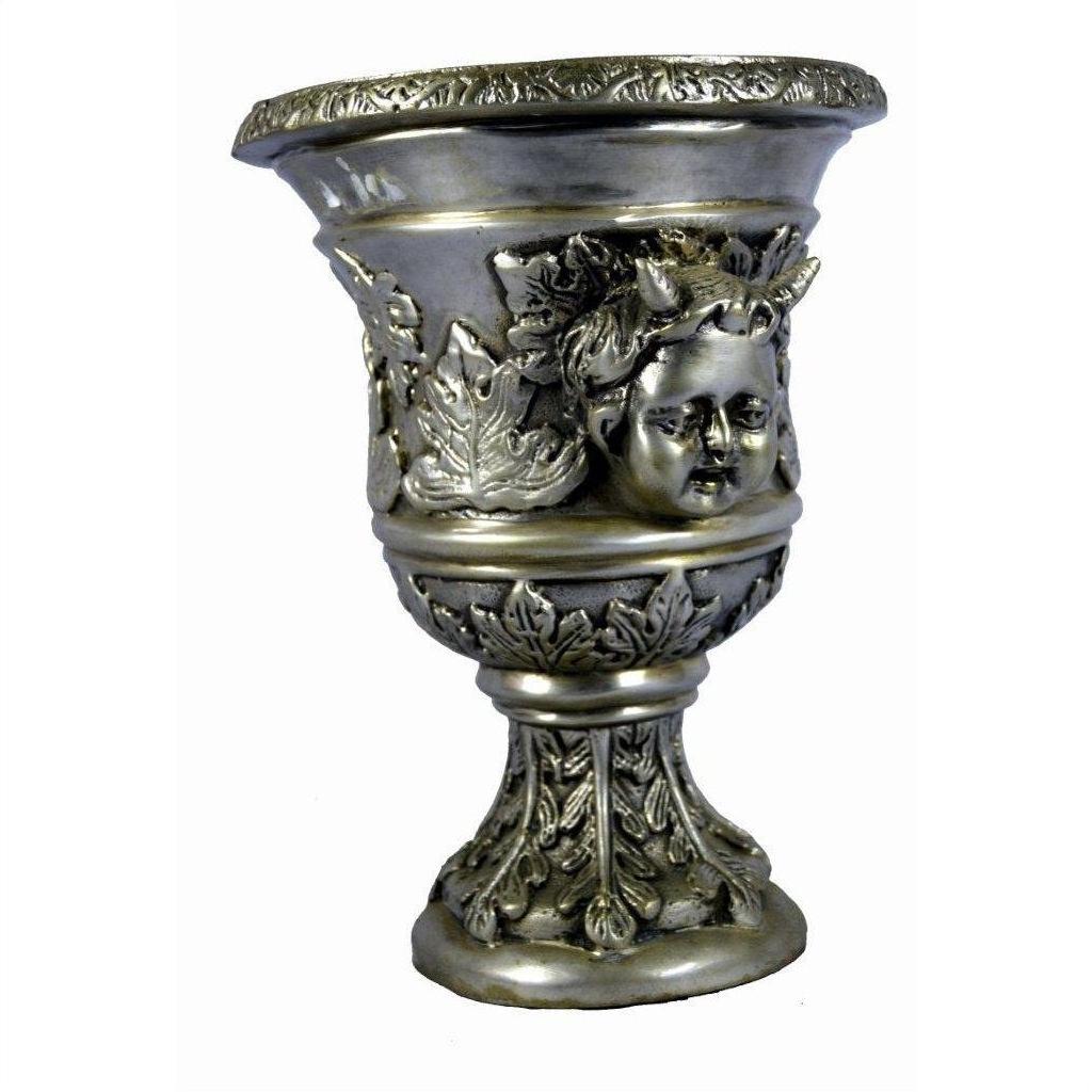 Silver plate urn with decorative leaf accents and cherub design on ornate base, close-up.