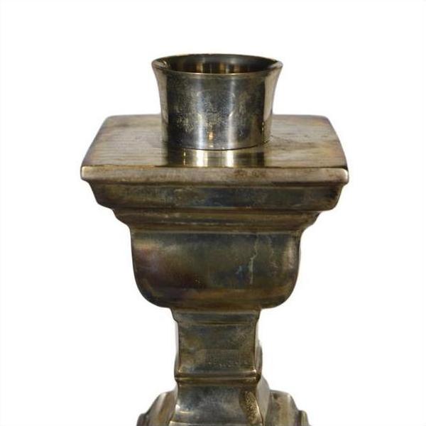 Silver plated brass candle holder with square base and round top in vintage Indian style, on white background.