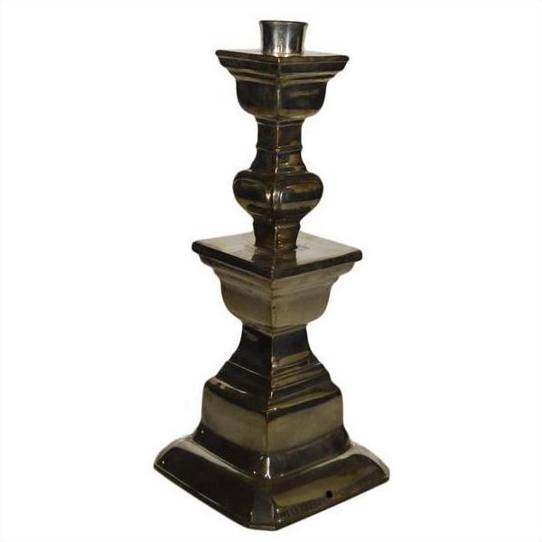 Close-up of a silver plated Indian brass candle holder with a square base and tiered geometric design.