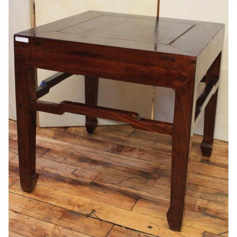Dark polished wood square table with angled horse hoof feet, set on a wooden floor.