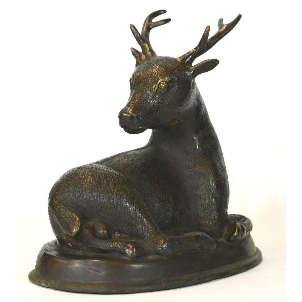 Bronze sitting deer sculpture with antlers on an oval base, close-up against a white background.