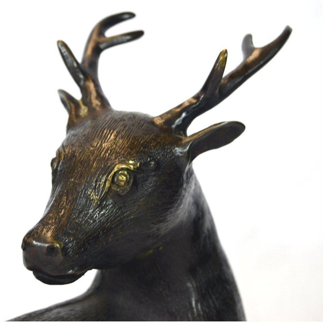 Close-up of bronze deer sculpture with detailed antlers and textured fur.